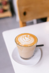 Wall Mural - One cappuccino on a white table in a coffee shop