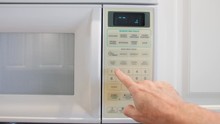 Using A Digital Keypad To Set The Microwave Oven Power Level And Microwaving Time For Cooking Or Reheating. Selecting Temperature And Cooking Timer Duration On Home Kitchen Appliance.
