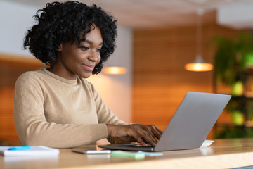 Wall Mural - Female blogger working at cafe, typing on laptop