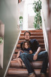 © Maskot - Portrait of smiling father with daughter sitting on steps at home