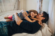 © Maskot - Mature father kissing his daughter while lying on bed
