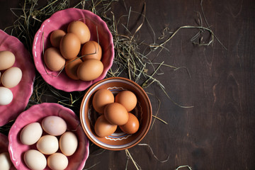 Wall Mural -  Preparing for Easter. Chicken eggs in colorful plates on a wooden table