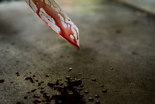 Close-up of the knife with blood stains and dripping on the floor.