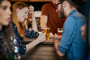 Poster - Group of friends drinking beer, chatting and having good time at pub. Night out.