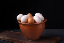 Fresh Chicken Eggs In A Clay Pot On A Black Background.