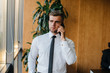 © Andrii - An employee in the office is standing near the window. Finance