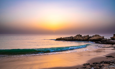 Swirl pattern of a wave rolling onto beach at sunset time