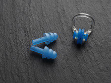Nose Clip And Ear Plugs For Swimming Pool On A Gray Background. Sport Equipment. Set Of Earplugs For Swimming And Clamp On The Nose