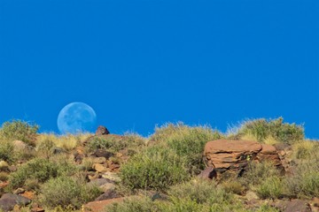 Wall Mural - Bright moon rising above in the blue sky in High Atlas Mountains in Morocco