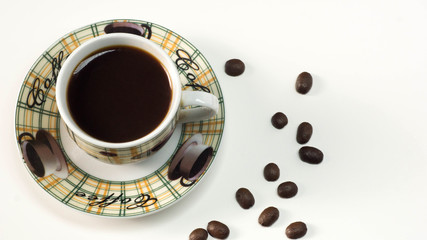 A Cup of hot coffee with scattered grains on a white table