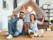 © JenkoAtaman - concept housing   young family. Mother father and child in new house with  roof at home