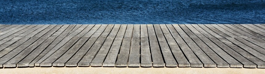 Close up of a wooden board walk along a little lake