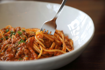 spaghetti Bolognese with minced beef and tomato sauce garnished with parmesan cheese and basil , Italian food