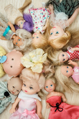 Many old dolls lies on floor in children room