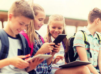 Wall Mural - primary education, friendship, childhood, technology and people concept - group of happy elementary 