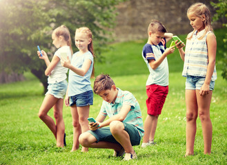 Poster - childhood, augmented reality, internet addiction, technology and people concept - group of kids or friends with smartphones playing game in summer park