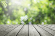 Wooden table and blurred fresh garden nature bokeh background.