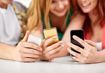 Wall Mural - technology and people concept - close up of hands with smartphones