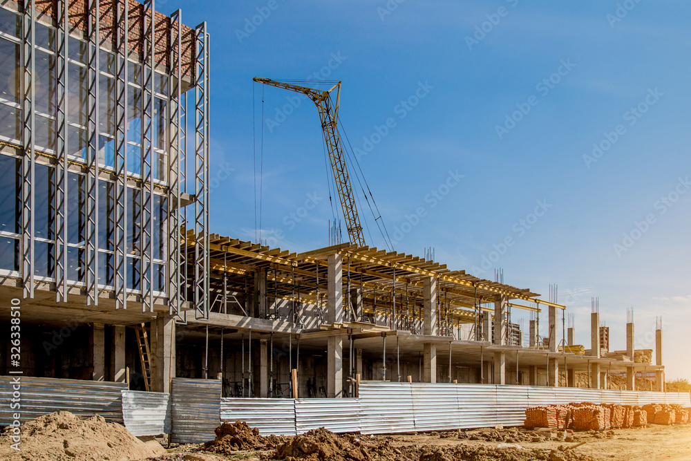 Construction site background. Hoisting cranes and new multi-storey buildings. I.ndustrial background.Building construction site work against blue sky - obrazy, fototapety, plakaty 