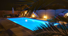Water Od Swimming Pool Illuminated In Blue By Night