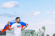 © Александр Коновалов - young guy with a stretched Russian flag on the site near a large stadium on a hot summer day before the start of a sports competition