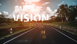 The word vision behind the tree of empty asphalt road at golden sunset and beautiful blue sky. Concept for vision.