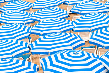 Striped blue white umbrellas. Abstract background