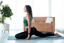Attractive Latin Woman Doing Yoga In Living Room. Pigeon Pose