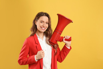 Young woman with megaphone on yellow background