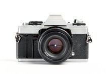 Front View Of A Classic Analog 35 Mm Camera Vintage And Analog Film Rolls On White Background
