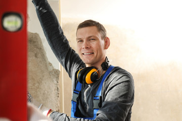 Canvas Print - Worker in uniform installing plastic window indoors