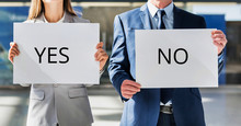 Business People Standing While Holding White YES Or NO Placard
