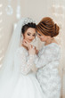 Daughter who became the bride gently embraces her mother. Mother of the bride blesses the bride for a happy family life.