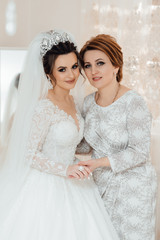 Daughter who became the bride gently embraces her mother. Mother of the bride blesses the bride for a happy family life.