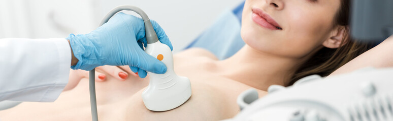 Wall Mural - panoramic shot of doctor making breast examination for patient using ultrasound scanner