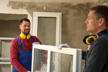 Canvas Print - Workers in uniform with new plastic window indoors