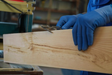 Poster - Professional carpenter measuring wooden board with sliding caliper in workshop, closeup