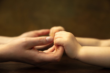 Holding hands, clapping like friends. Close up shot of female and kid's hands doing different things together. Family, home, education, childhood, charity concept. Mother and son or daughter, wealth.