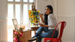 © Prathankarnpap - Young beautiful artist girl sitting in front the drawing canvas while painting an oil color at the modern studio. Beautiful artist and gallery studio concept.