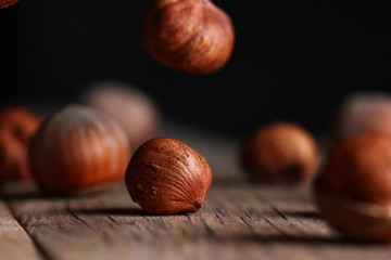 Sticker - a hazelnut and a broken shell close up on a cracked wooden table