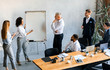 © Prostock-studio - Black Businesswoman Presenting Business Idea To Colleagues In Modern Office