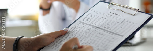 Cuadros en Lienzo Female visitor filling out medicine documents in doctor office close-up