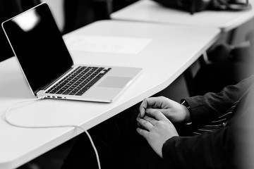 Ordinateur portable d'une personne écoutant une conférence en Noir et Blanc