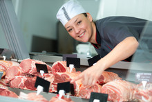 Female Butcher In Meat Store Counter
