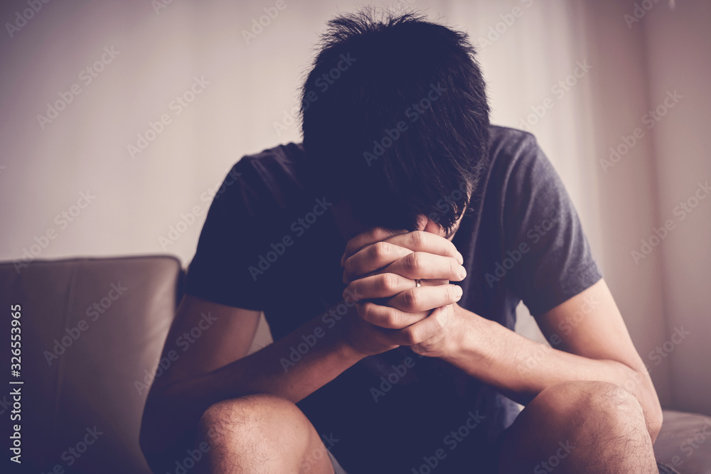 Depressed, and anxiety young man sitting alone and praying at home, social distance, mental health, men health, online home church concept - obrazy, fototapety, plakaty 