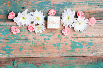 Poster - Flower border with gift box and copy space on old wooden turquoise background.