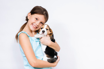 Teen girl holding beagle dog.