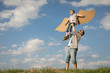 © altanaka - Father and son playing with cardboard toy wings