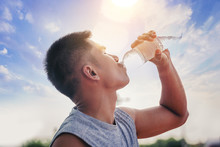 Runner Man Drinking Pure Water From Plastic Bottle After Workout With Sunrise Background. Selected Focus
