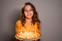 A Teen Girl Holding Pizza With Candles Is Smiling